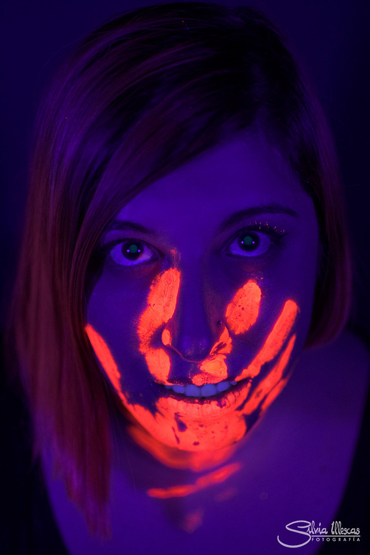 Cara de mujer en la oscuridad con pintura fluorescente maquillaje detrás de  un velo blanco bajo las luces negras Fotografía de stock - Alamy