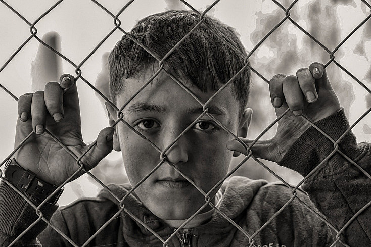 Fotografía de un niño tras una reja