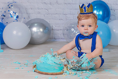 Bebé de 1 año en un estudio fotográfico con un pastel y globos